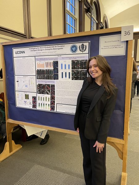 Rylie Starer standing in front and to the right of her scientific poster